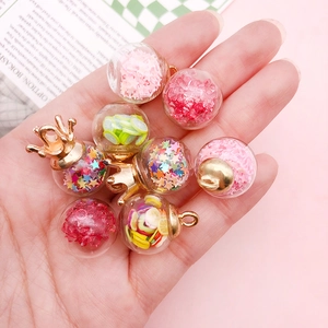 Close-up of glass pendants filled with pink stars and fruit slices for DIY jewelry