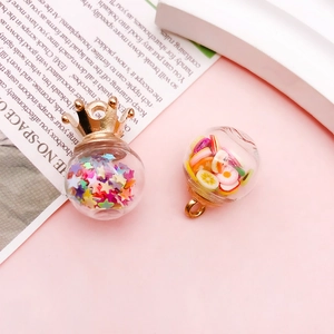 Detailed view of DIY glass bottle pendants with fruit clay slices and star sequins charms