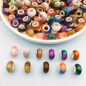 Macro detail of multicolored cat eye resin beads with silver large hole metal cores