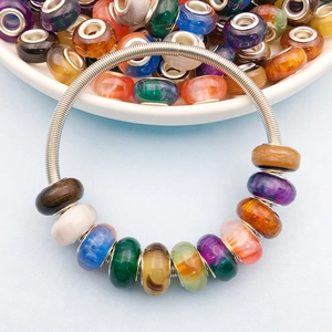 Macro view of colorful resin cat-eye beads on a silver spring coil bracelet design