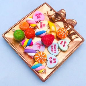 Dettaglio di ciondoli in resina a forma di frutta e marshmallow per gioielli fai-da-te