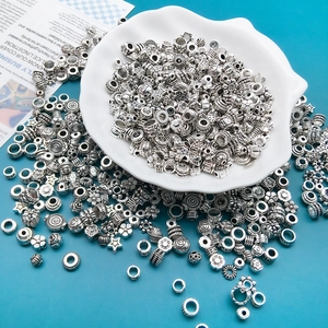 Makroaufnahme von antiken silbernen Zwischenperlen mit Blumenrelief für DIY Schmuck