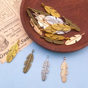 Vue détaillée de breloques en métal en forme de plume pour la création de bijoux DIY