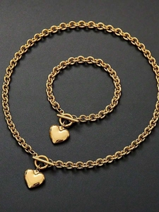 Détail d'un ensemble de bijoux coeur en acier doré avec fermoir à bascule en T