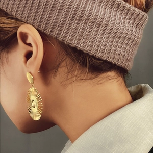 Boucles d'oreilles pendantes géométriques dorées avec un design solaire métallique chic