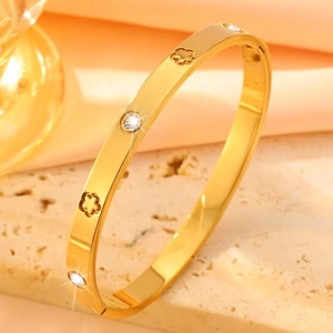 Gepolijste gouden titanium stalen armband met klaverpatronen en ingelegde kristallen details