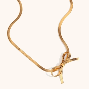Élégant collier en maille serpent dorée avec un design de nœud papillon stylisé