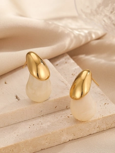 Gros plan sur des boucles d'oreilles goutte d'eau couleur bonbon avec dessus doré poli