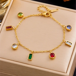 Bracelet en acier doré avec pendentifs en zircon colorés sur boîte à bijoux