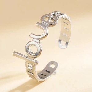 Macro shot of silver titanium steel ring with hollow LOVE letter design and open band