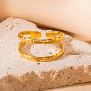 Detail eines zweischichtigen Goldrings mit Hammerschlag-Textur auf Steingrundlage