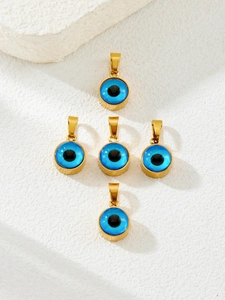 Macro shot of five blue Evil Eye pendants with gold plating on white textured background