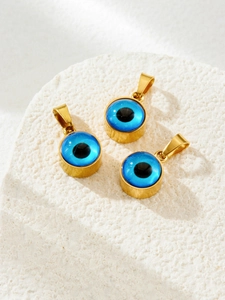 Detail view of blue evil eye pendants with golden frames on a white stone background