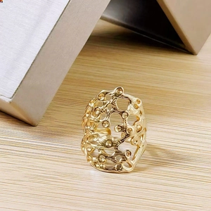 Detailed shot of golden hollow organic geometric ring with artistic cellular design