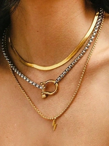 Close-up of layered 18k gold plated box chain and lightning bolt pendant necklace set