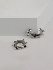 Détail de boucles d'oreilles punk en acier inoxydable avec pointes métalliques