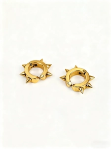 Vue détaillée des boucles d'oreilles punk dorées polies avec pointes métalliques