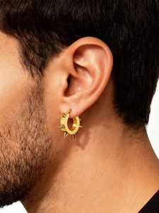 Détail d'une boucle d'oreille punk dorée pour homme avec cinq rivets coniques pointus