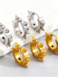 Gros plan de boucles d'oreilles punk en acier inoxydable avec rivets coniques dorés et argentés