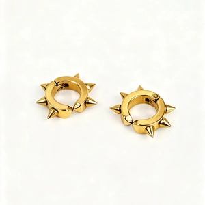 Paire de boucles d'oreilles punk or avec six rivets coniques sur fond blanc