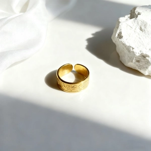 Detalle del anillo de hoja dorada con grabados florales y estructura ajustable