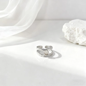 Anillo calado plateado de estilo francés con líneas curvas y piedra blanca redonda