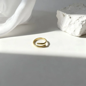 Anillo de oro en espiral de lujo sobre seda blanca y piedra de diseño minimalista