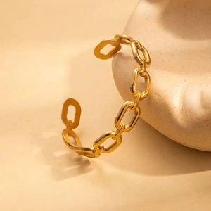Detailansicht eines minimalistischen goldenen Gliederketten-Armbands auf Keramik