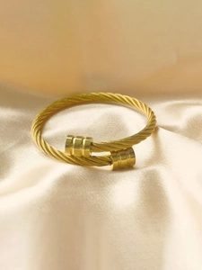 Dettaglio del bracciale a cavo dorato in acciaio inossidabile con terminali scanalati