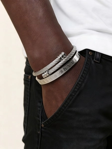 Dettaglio del set bracciale a cavo d'argento e polsino con numeri romani al polso maschile