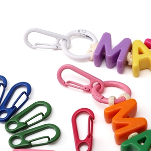 Vista macro di moschettoni colorati e perline con lettere per creazioni fai-da-te