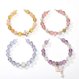Macro shot of colorful transparent glass beads with pearl and butterfly pendants