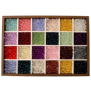 Top view of 24-compartment wooden box with colorful transparent glass beads for DIY crafts