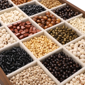 Macro detail of various dark wooden beads in a divided storage box for DIY jewelry