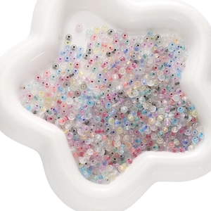 Mix of colorful round glass beads with rainbow cores for DIY jewelry making in star tray