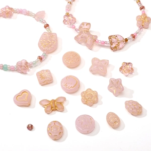 Macro shot of assorted pink Czech glass beads with gold butterfly and heart motifs