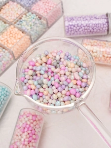 Macro shot of macaron colored glass pebbles in a glass cup for DIY jewelry making