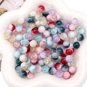 Close-up of colorful cracked glass beads for DIY jewelry making in a white tray