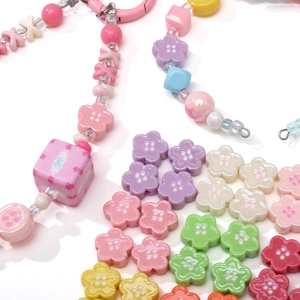 Gros plan de perles fleurs en acrylique colorées de 12mm pour la création de bijoux DIY
