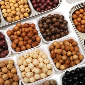 Natural sandalwood and assorted wooden beads in white bowls for DIY jewelry making