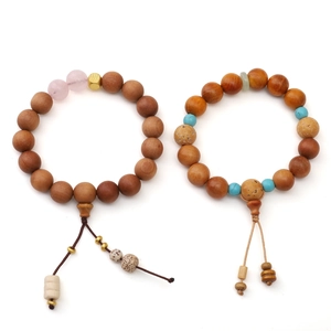 Braccialetti etnici in legno con pietre naturali e nappe in stile Zen su sfondo bianco