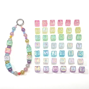 Macro detail of acrylic laser-coated letter cubes and handmade bead charms set
