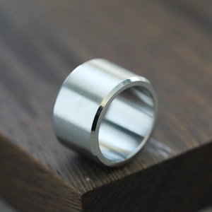 Macro shot of silver stainless steel ring with horizontal brushed finish and polished edges