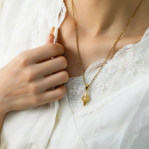 Elegant gold diamond pendant necklace with starburst texture on a female model