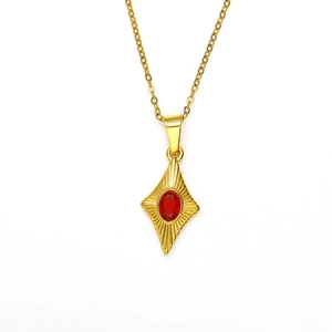 Detail of gold necklace featuring a rhombic pendant with a red stone and sunburst pattern