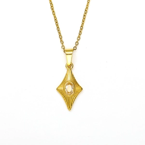 Detailed view of gold rhombus pendant with oval cubic zirconia on fine cross chain