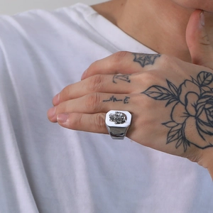 Detailed view of punk skull signet ring in polished stainless steel on model's hand