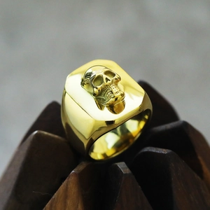 Close-up of a gold signet ring for men featuring a detailed 3D punk skull relief design