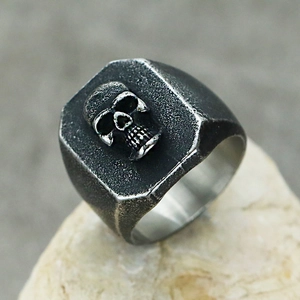 Macro shot of a 3D skull punk ring on stone with vintage oxidized stainless steel finish
