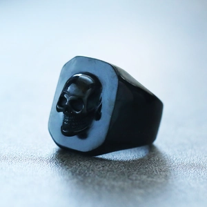 Macro shot of punk style black titanium steel ring with 3D skull relief for men
